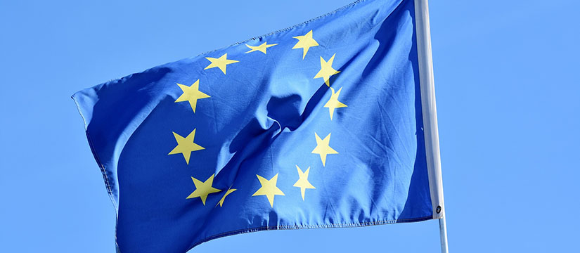 EU-flaggan som vajar i vinden mot klarblå himmel.