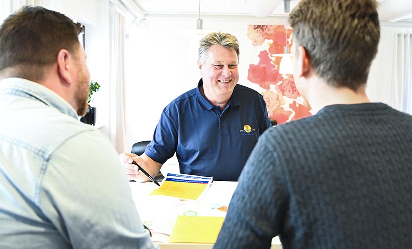 Vår säljare Per-Göran Andersson sitter ner och pratar med två män som är blivande kunder.